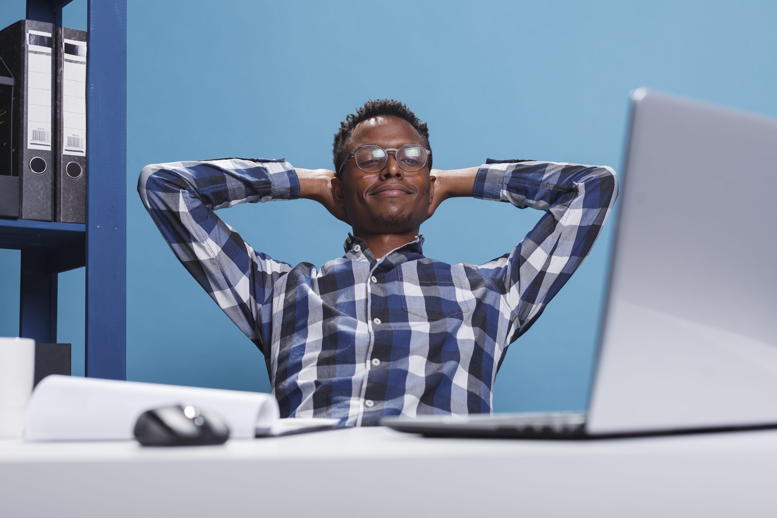 Calm and zen stress free man in company workspace thinking about what to do after work.